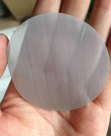 One single layer extruder screen disc in one hand.